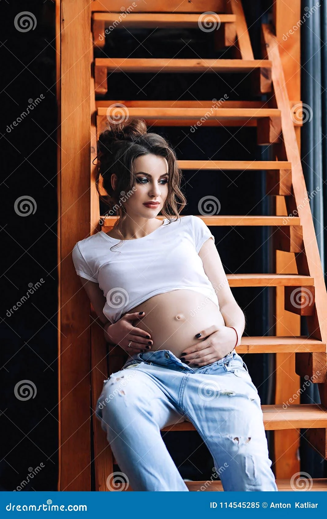 Беременная в футболке и джинсах