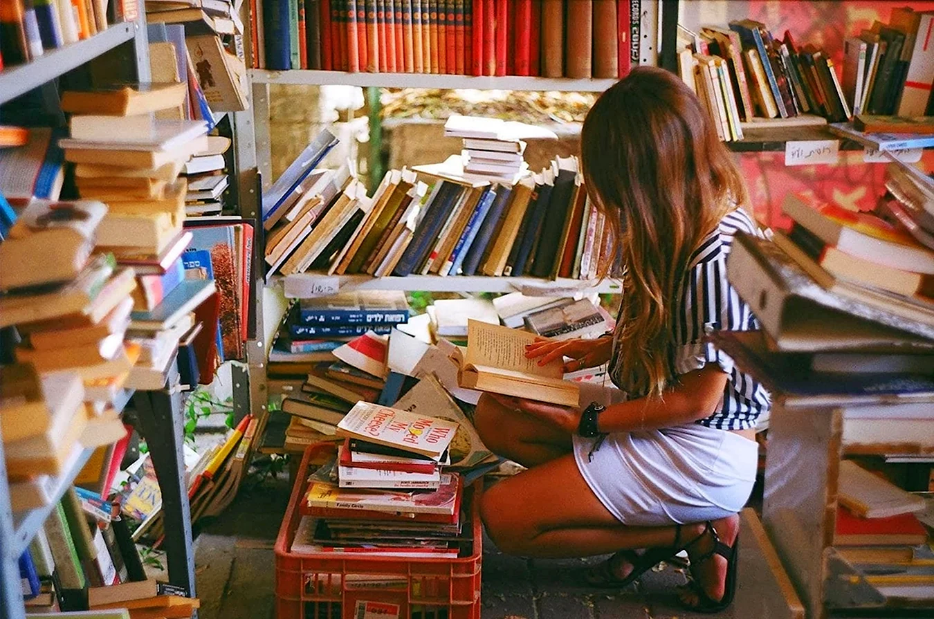 Девушка читает в библиотеке