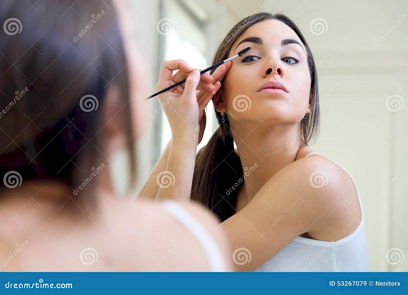 Девушка делает макияж перед зеркалом