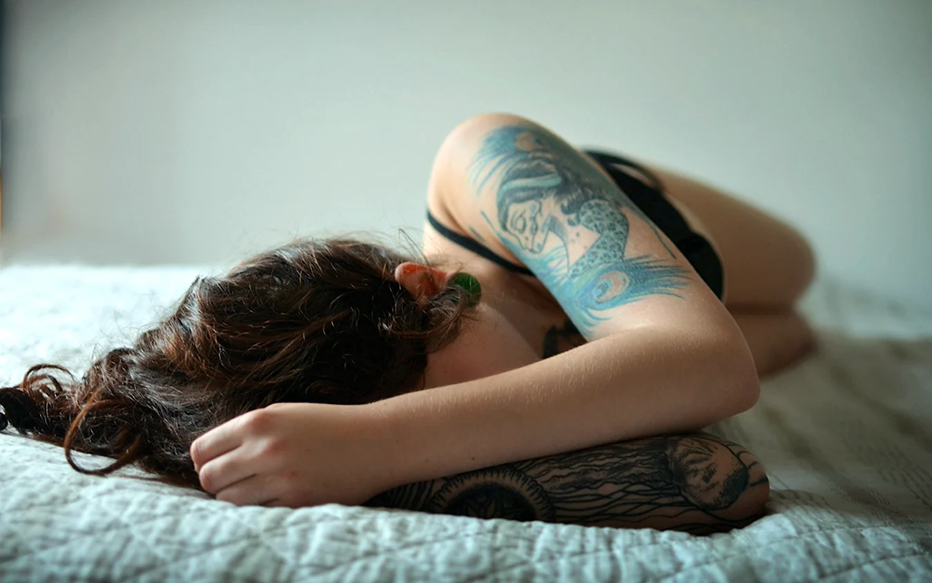 Девушка лежит с татуировками