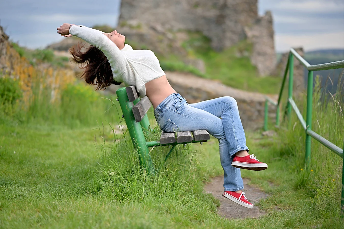 Девушка в джинсах на траве