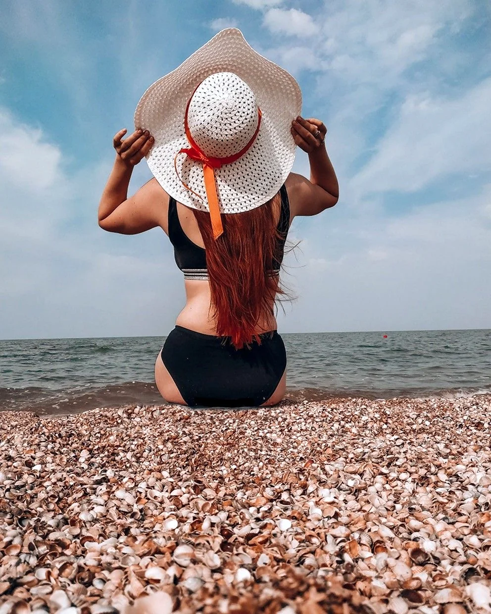 Девушка в шляпе на море