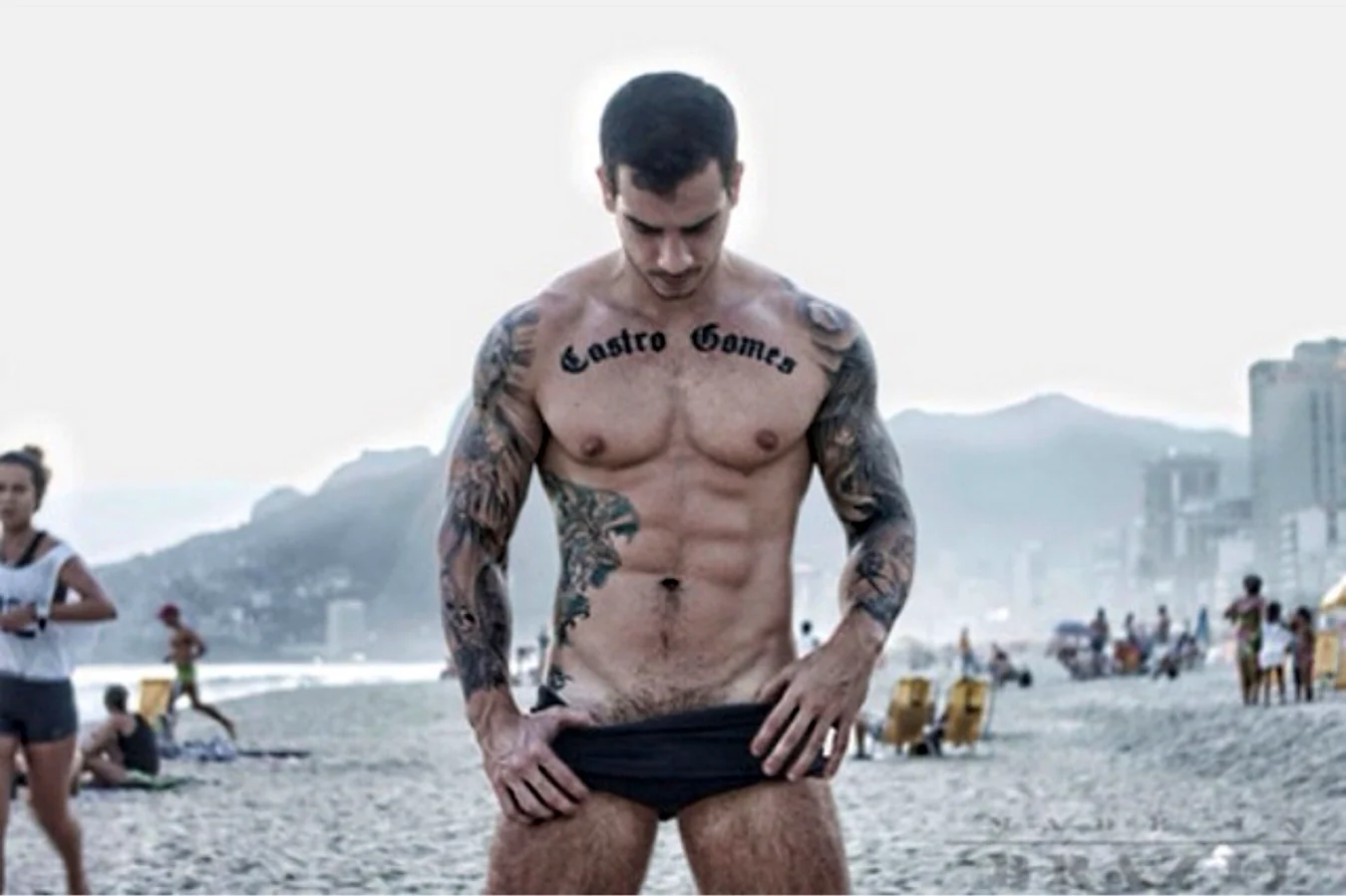 Накачанный мужчина в тату на пляже