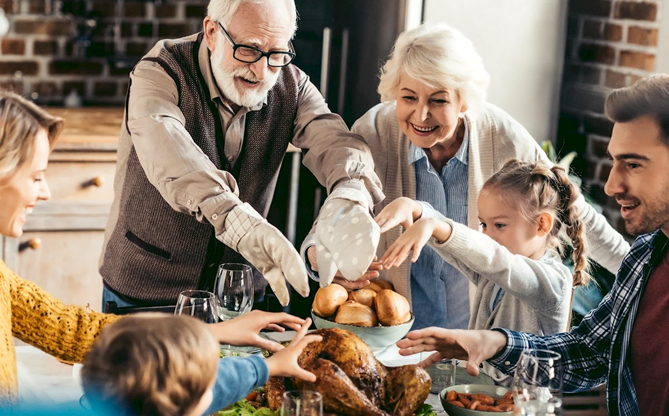 Счастливая семья с бабушками и дедушками за столом