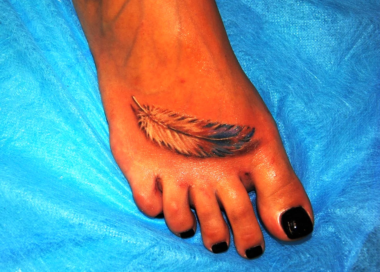 Татуировка перышко на ноге